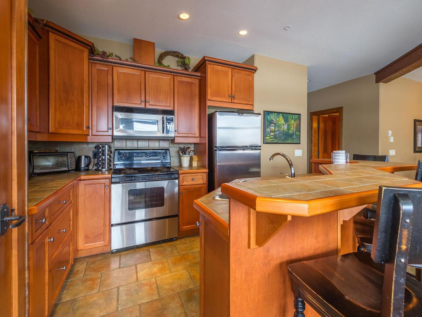 Spyglass 5C's gourmet kitchen with traditional chalet touches and stainless steel appliances, managed by Luxury Mountain Vacation Rentals at Big White Ski Resort
