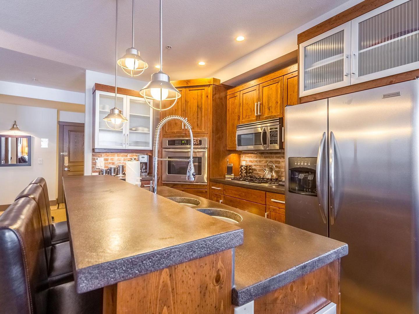 Timbers 301's luxury gourmet kitchen with stainless steel appliances and modern touches, managed by Luxury Mountain Vacation Rentals at Big White Ski Resort.
