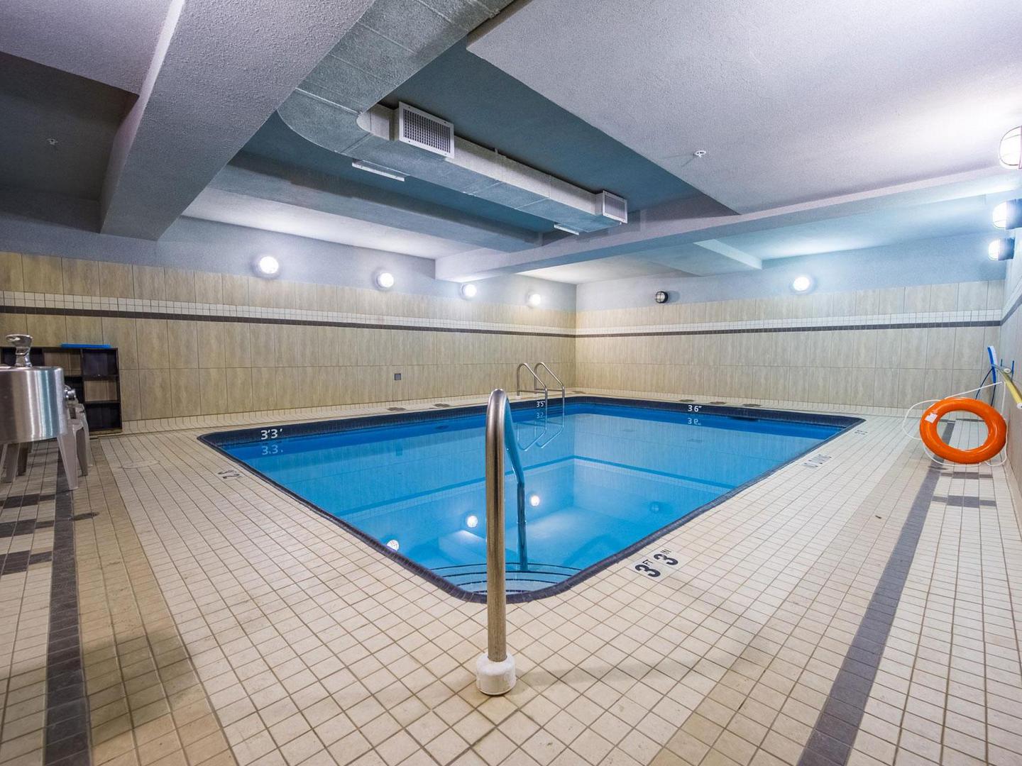 The indoor pool with light coloured tiling at the Raven, a luxury rental building at Big White Ski Resort managed by Luxury Mountain Vacation Rentals.