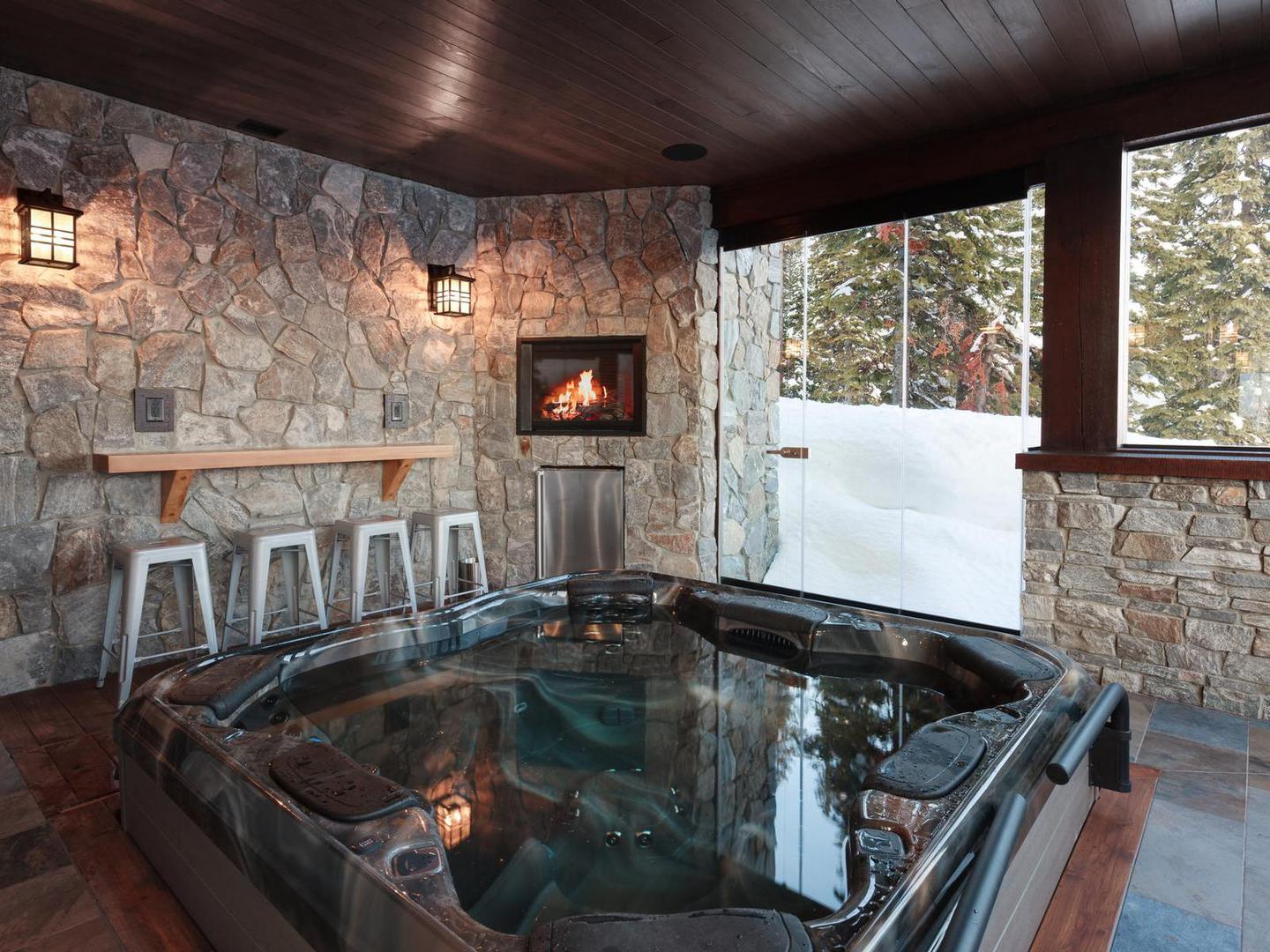 The luxury 8-person private hot tub with a bar and fireplace in the luxury vacation rental White Caviar at Big White Ski Resort.