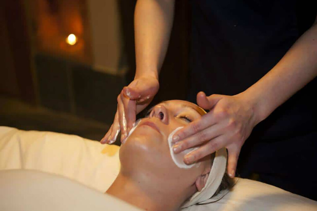 An adult is lying on a massage table. She is relaxed while getting a massage.
