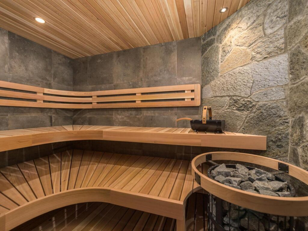 A wooden and stone sauna at Snow Peaks luxury chalet, one of Luxury Mountain Vacation Rentals' properties at Big White Ski Resort.