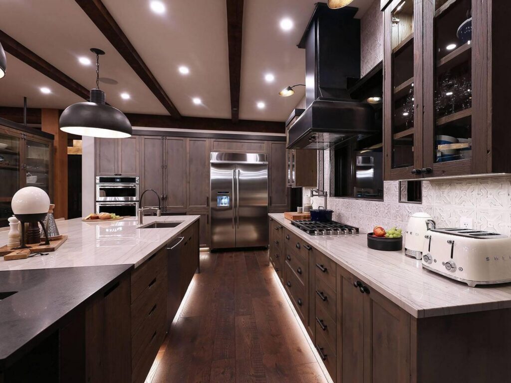 A modern gourmet kitchen with dark cabinetry and accents in a luxury ski vacation rental.