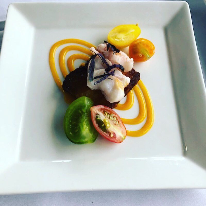 A plate of gourmet food made by Backyard Farm Chef's Table for a private culinary experience, with bright yellow and green colours.