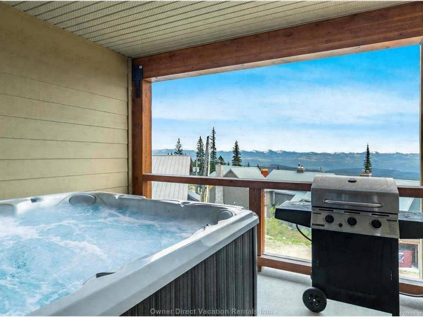 The private deck with a hot tub, bbq and gorgeous view at Aspens #6 at Big White Ski Resort.