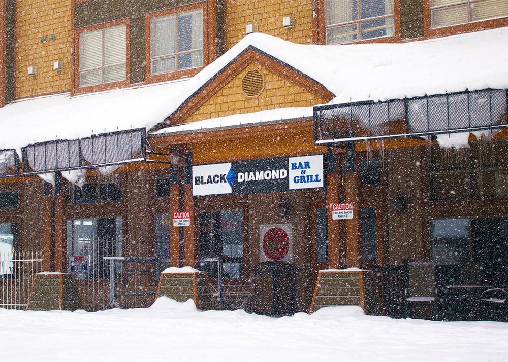 Outside of the Black Diamond Grill at Big White on a snowy day.