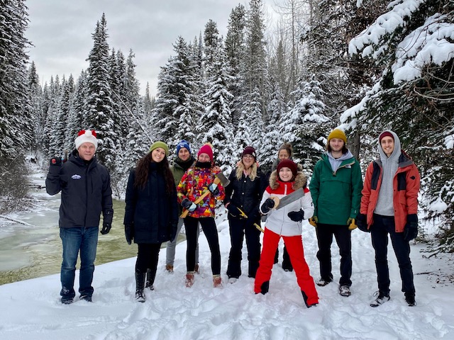 The Luxury Mountain Vacation Rentals employees stand and pose in their winter gear on a snowy day at Big White Ski Resort.