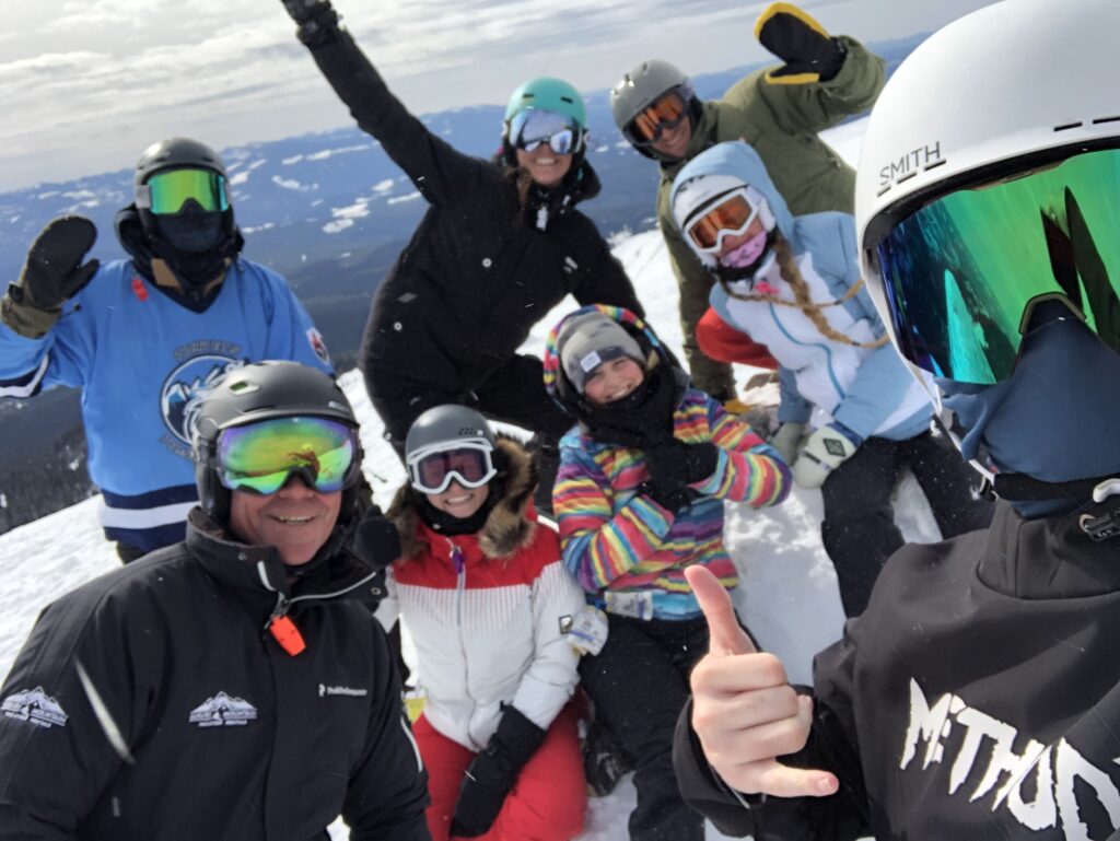 The employees at Luxury Mountain Vacation Rentals stand and pose in their mountian gear for a group photo at Big White Ski Resort. 