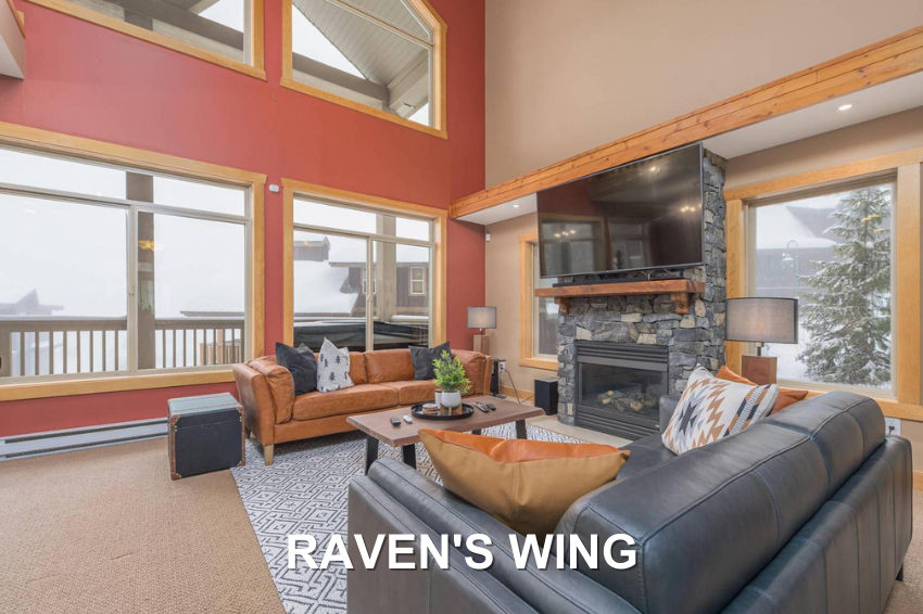 Raven's Wing's luxury living room with two comfortable leather couches, stone fireplace and large windows, a vacation rental managed by Luxury Mountain Vacation Rentals at Big White Ski Resort.