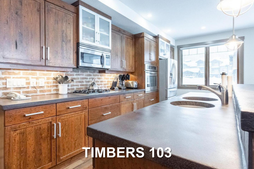 Timbers 103's luxury gourmet kitchen with modern countertops and cabinets and bright natural light, a corner suite condo vacation rental managed by Luxury Mountain Vacation Rentals at Big White Ski Resort.