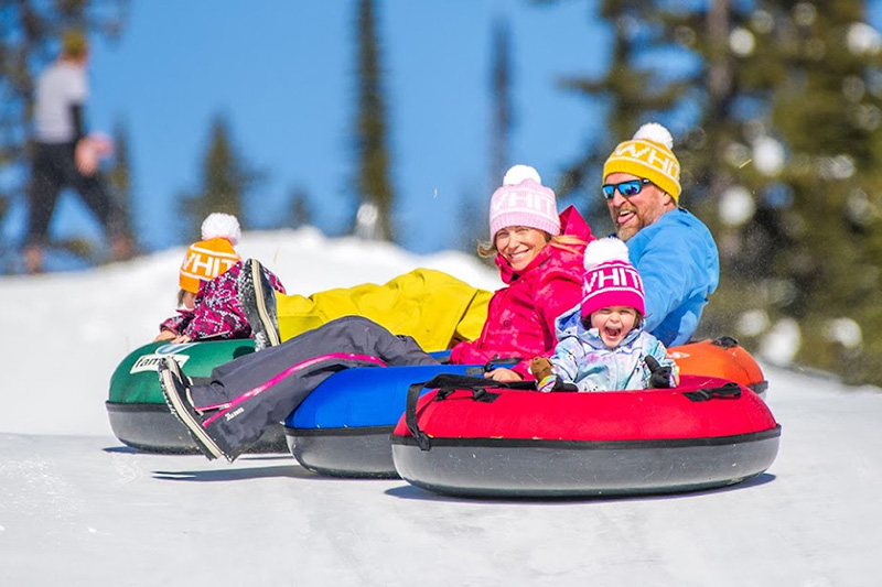 A family tubing at Big White Ski Resort's Happy Valley area.